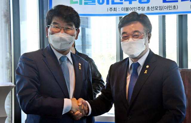 더불어민주당 원내대표 선거에 출마한 윤호중 의원(오른쪽)과 박완주 의원이 14일 서울 영등포구 서울마리나클럽에서 열린초선의원 모임 '더민초'의 초청토론회에서 악수하고 있다. (사진= 연합뉴스) 