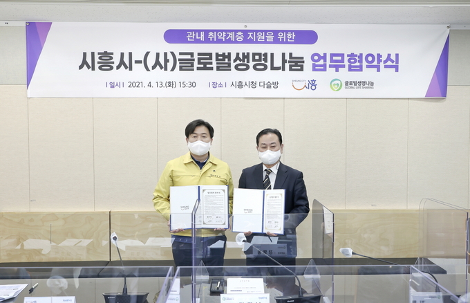 시흥시와 ㈔글로벌생명나눔이 관내 취약계층 지원을 위한 업무협약을 체결한 가운데 임병택 시흥시장과 김정남 ㈔글로벌생명나눔 대표가 협약서를 들어보이고 있다. (사진=시흥시 제공)