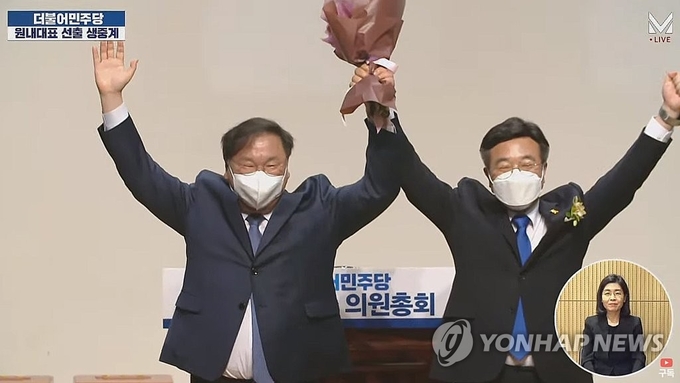 16일 오전 국회 의원회관에서 열린 더불어민주당 원내대표 선출을 위한 의원총회에서 신임 윤호중 원내대표(오른쪽)가 전임 김태년 원내대표와 손을 들어 인사하고 있다. (사진=연합뉴스 제공)