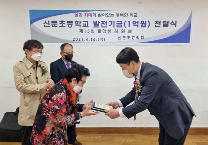 신문초등학교 졸업생 김원순씨가 모교에 학교발전기금을 전달하고 있다. (사진=이천교육지원청 제공)