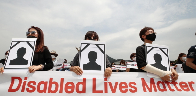 '장애인의 생명도 소중하다' 지난해 6월 10일 오전 청와대 분수대 앞에서 발달장애인 가족들이 기자회견을 하는 모습. (사진=연합뉴스)