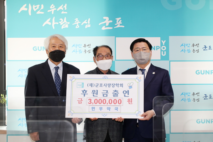 오른쪽부터 한대희 군포시장, 민우약국 배정명 대표, 이명근 (재)군포사랑장학회 이사장.