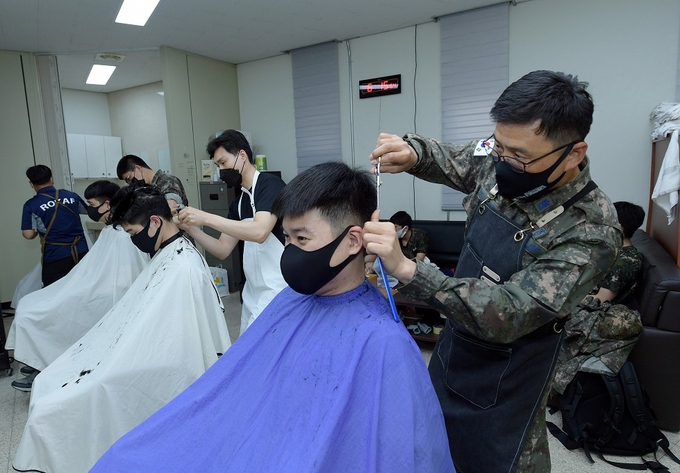 항공정비전대 이린우 원사 등 장병들이 코로나19 상황으로 외부 미용업체가 부대에 방문하지 못해 이발을 하지 못하는 장병들을 위해 이발 재능기부 활동을 진행하고 있다. (사진=공군 15비 제공)
