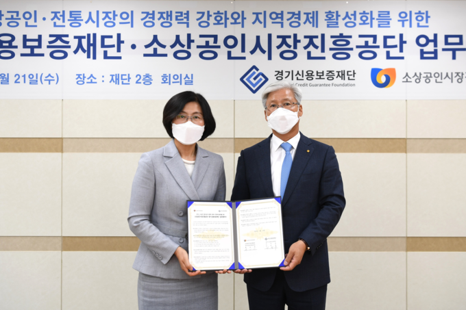 이민우 경기신보 이사장(오른쪽)이 황미애 소진공 본부장과 21일 경기신보 회의실에서 도내 소상공인·전통시장의 경쟁력 강화와 지역경제 활성화를 위한 업무협약을 체결했다.(사진= 경기신보 제공)
