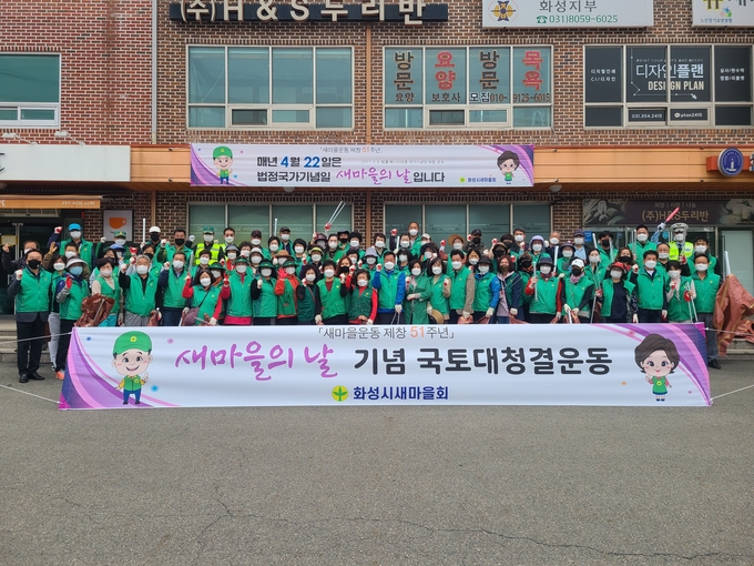 22일 제11회 새마을의 날을 맞아 화성시새마을회 회원 80여 명이 국토대청결운동을 마치고 기념촬영을 하고 있다.(사진=화성시새마을회 제공)
