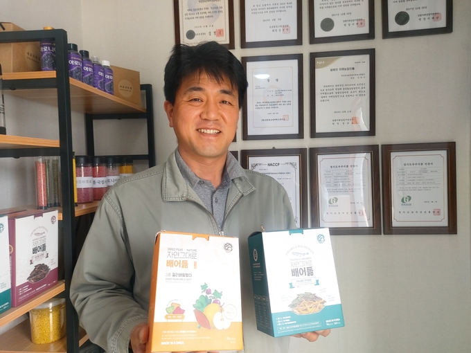 김명수 '엄마손꾸러미영농조합’ 대표가 자체 브랜드 '자연그대로 배어듦' 제품을 들고 환하게 웃고 있다. (사진=편지수 기자)