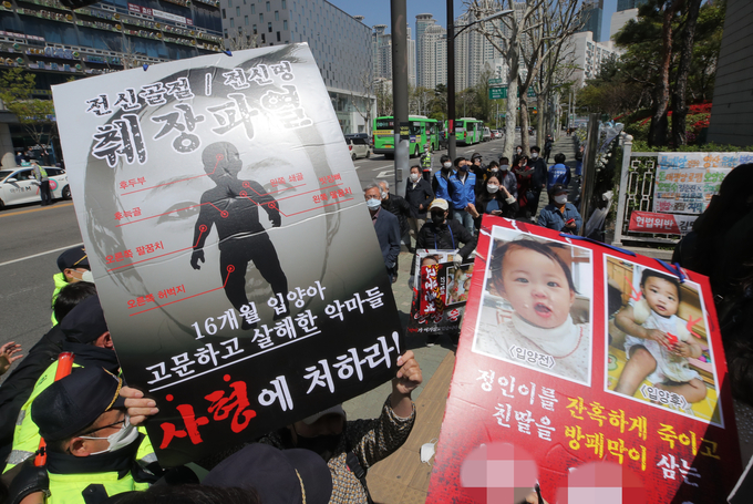 지난 14일 16개월 된 입양 딸 정인 양을 학대해 숨지게 한 혐의로 기소된 양부모 결심 공판이 열리는 서울남부지법 입구에서 시민들이 양모가 탑승한 것으로 보이는 호송차를 향해 팻말을 들고 항의하고 있다. (사진=연합뉴스 제공)