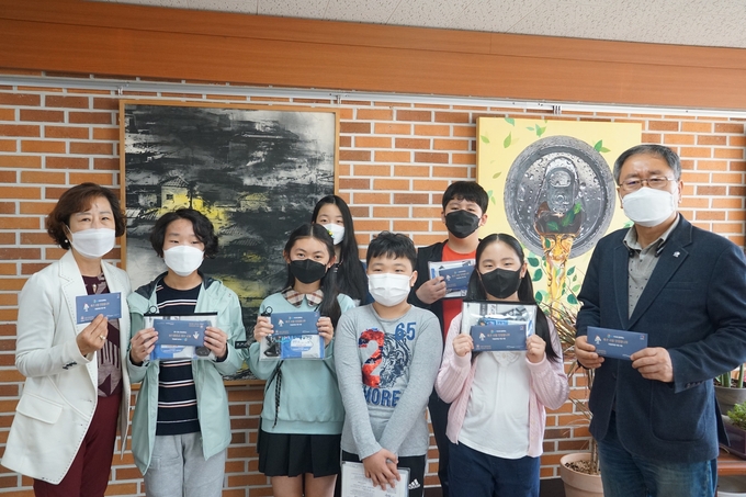 GS파워가 ‘축구 사랑 안양꿈나무’ 장학생에 FC안양 시즌권 선사하고 있다.