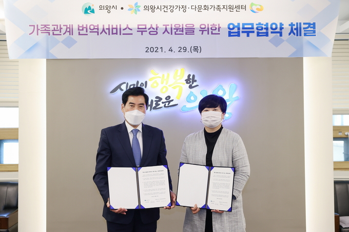 김상돈 의왕시장과 정성순 의왕시건강가정·다문화가족지원센터장이 ‘국제 가족관계 번역서비스 지원 사업’을 위한 업무협약을 체결한 뒤 협약서를 들어보이고 있다. (사진=의왕시 제공)