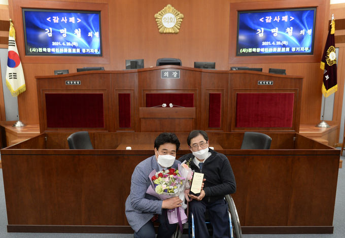 김명철 의원이 지난달 29일 의회 본회의장에서 ㈔전국장애인야학협의회 경기지부로부터 ’감사패‘를 받고 있다.