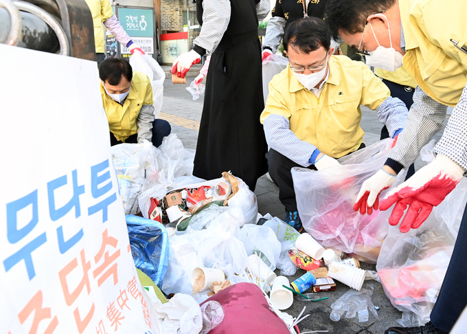 조청식 수원시 제1부시장이 무단 투기된 재활용 쓰레기를 분리하는 작업을 하고 있다.