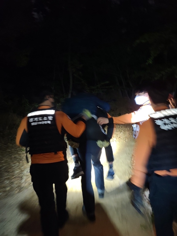 60대 치매노인이 구조대원 등에 업혀 산을 내려오고 있다. (사진=성남소방서 제공)