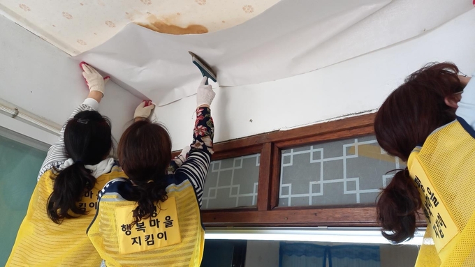 파주 파평형 행복마을관리소 회원들이 도배를 실시하고 있다. (사진=파주시 제공)