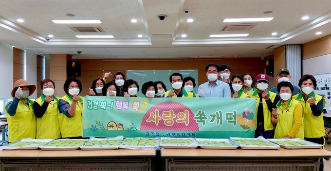 파주읍 누리보듬협의체 회원들이 이웃에 전달할 쑥개떡을 앞에 두고 있다. (사진=파주시 제공)