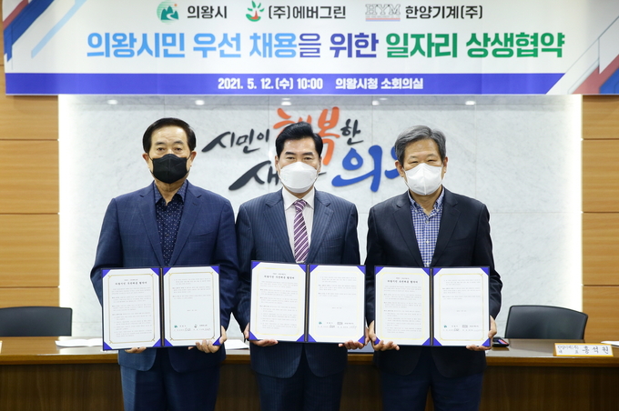 김상돈 의왕시장(사진 가운데)이 의왕테크노파크 입주기업인 ㈜에버그린, 한양기계㈜ 관계자들과 함께 일자리 상생을 위한 협약을 맺고 각자 서명한 협약서를 들어보이고 있다. (사진=의왕시 제공) 