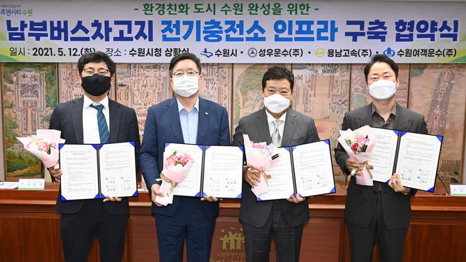 12일 오후 수원시청 상황실에서 개최된 ‘남부버스차고지 전기충전소 인프라 구축 협약식’에서 염태영 수원시장(왼쪽 두 번째)과 시내버스업체 대표들이 협약서를 들고 기념촬영을 하고 있다. (사진=수원시 제공)