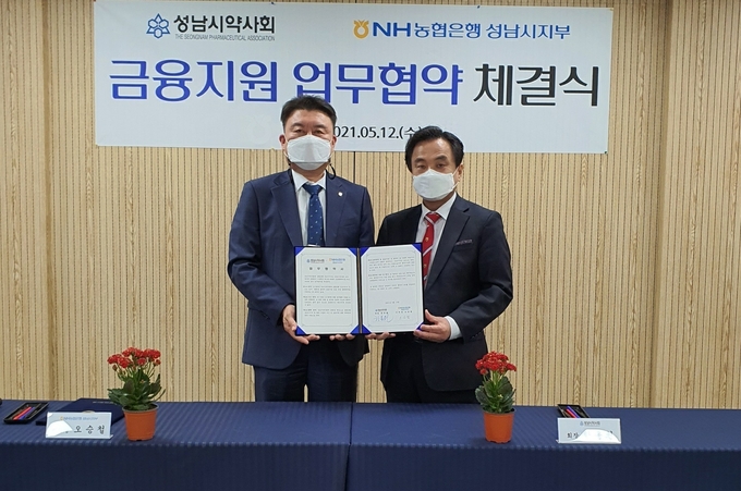 오승철 지부장(사진 왼쪽)과 한동원 약사회장이 업무협약 후 기념촬영을 하고 있다. (사잔=NH농협은행 제공)