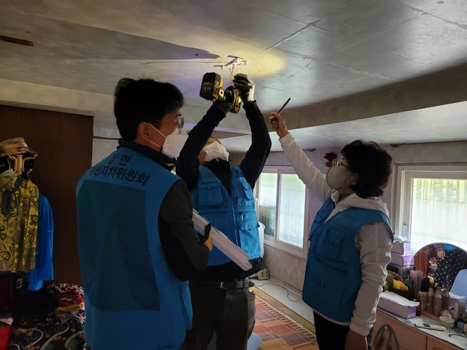 가평군 상면 주민자치위원회 위원들이 지역 내 독거노인 가구를 찾아가 노후된 조명을 LED조명으로 교체하는 봉사활동을 하고 있다. (사진=가평군 상면사무소 제공)