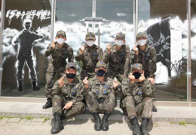 재능기부 장병들이 작업이 완료된 복지대대 병사식당 유리벽 앞에서 기념촬영을 하고 있다. 사진=김샛별 중사