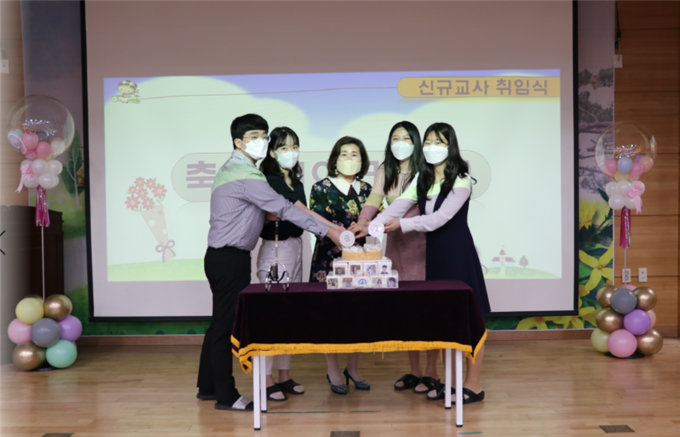 새내기 교사 4명이 취임식에 마련된 환영 케익크를 자르고 있다.(사진= 김포 신곡초 제공)