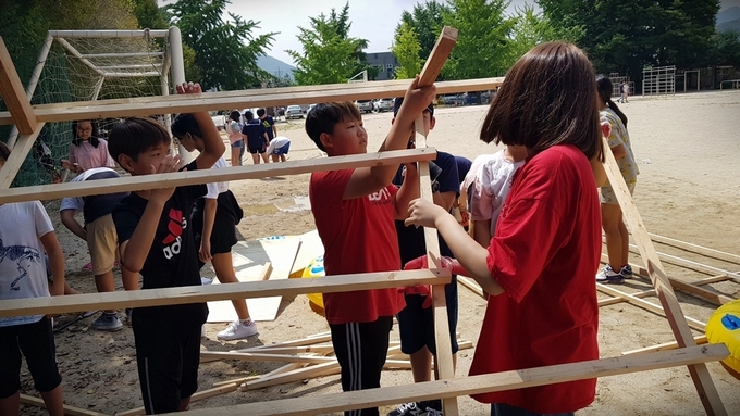 서종초 학생들이 북한강을 건너기 위해 직접 뗏몰을 만들고 있다. (사진=서종초등학교 제공)