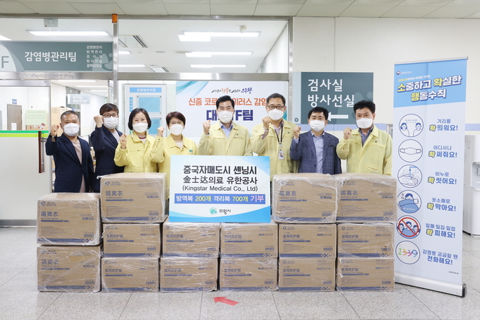 김상돈 시장을 비롯한 의왕시 관계자들이 중국 후베이성 셴닝시에서 전달한 방역물품 앞에서 기념촬영을 하고 있다. (사진=의왕시 제공)