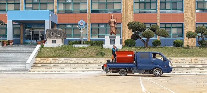화성오산교육지원청 교육시설관리센터가 한 학교 운동장에 소금을 포설하는 모습. (사진=경기도교육청)