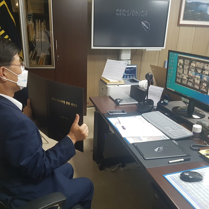 한대희 군포시장이 ‘탄소중립 실천 특별세션’에 온라인으로 참여해 탄소중립 공동선언문에 서명한 뒤, 다른 지자체장들과 함께 선언문을 들어보이고 있다. (사진=군포시 제공)