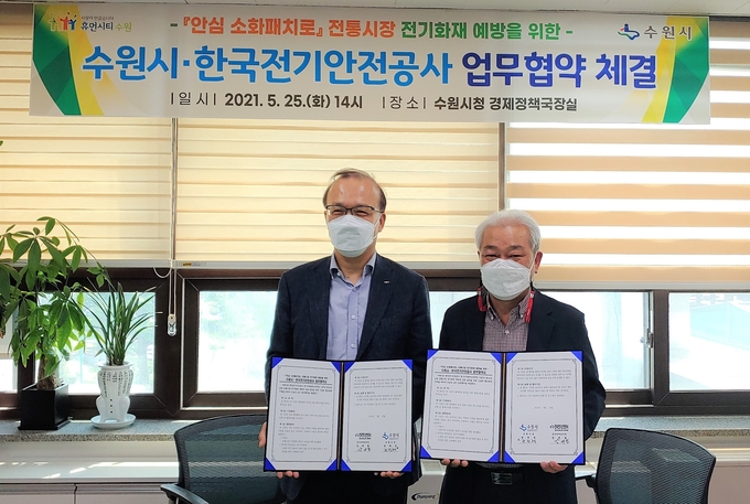 조진행 수원시 경제정책국장(오른쪽)과 강대철 한국전기안전공사 경기지역본부장이 기념촬영을 하고 있다. (사진=수원시 제공)