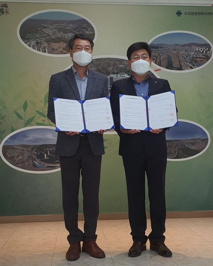 광주시 권용석오포읍장(사진 오른쪽)과 지우종 엔티산업㈜ 대표가 회사 토지를 무료로 사용하는 협약을 맺고 서로 서명한 협약서를 들어보이고 있다. (사진=광주시 제공)