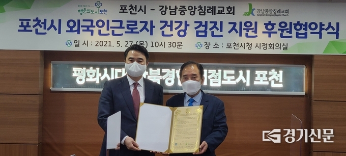 박윤국 포천시장과 최병락 강남중앙침례교회 담임목사가 서명한 협약서를 들어보이고 있다. (사진=문석완 기자)