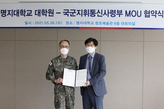 국군지휘통신사령부 박일수 사령관(왼쪽)과 명지대학교 선정원 연구부총장(오른쪽)이 협약식을 들고 기념사진을 촬영하고 있다. (사진=명지대학교 제공)