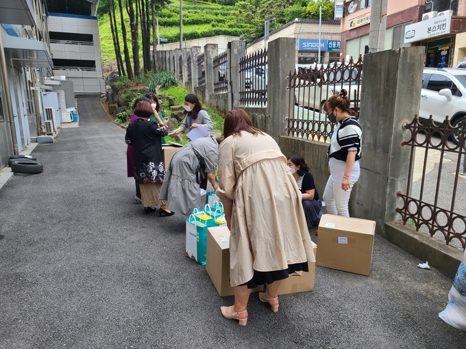 군포시가 어린이집연합회 관계자들에게 화재대피용 방연마스크를 전달하고 있다.
