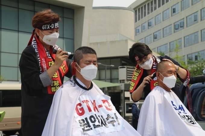민주당 박상혁·김주영 국회의원 이 세종시 국토부 앞에서 삭발을 하고 있다. (사진=독자 제공)