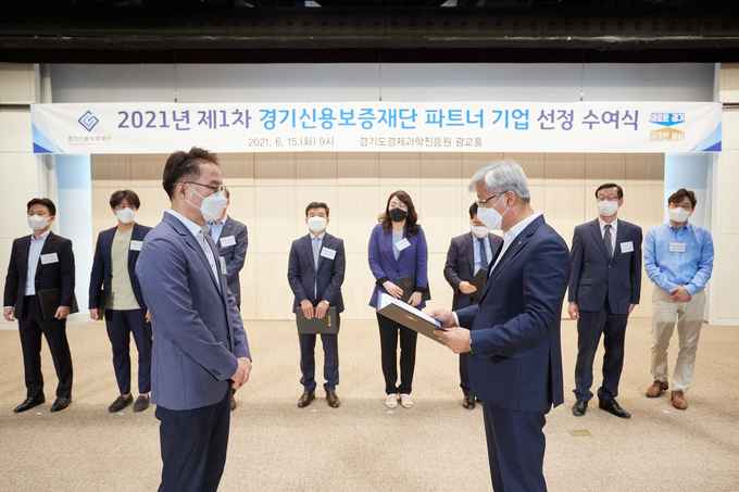 이민우 경기신용보증재단 이사장(오른쪽)이 15일 경기도경제과학진흥원 광교홀에서 경기신보 파트너 기업에 선정서를 수여하고 있다. (사진= 경기신보) 