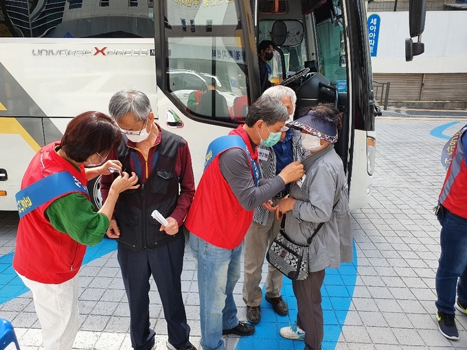 코로나 2차백신 접종완료자에게 주민자치위원들이 안심배지를 부착하는 모습 (사진= 동두천시 제공)