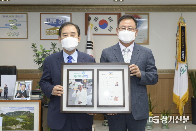 박윤국 포천시장과 김영오 포천메나리 무형문화재 보유자가 무형문화재 보유자 인정서를 들어보이고 있다. (사진=포천시 제공)