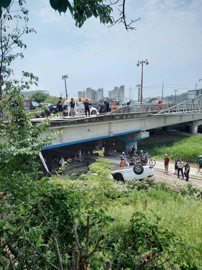 남촌대고 난간이 힘없이 부서지면서 자동차가 추락했다. 현장에 출동한 구급대원이 운전자를 구출하고 있다. (사진=지명신 기자)