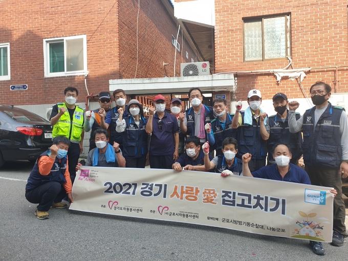 사) 군포시 자원봉사센터가 2021 경기 사랑 애 집고치기 사업을 펼친뒤 기념사진.