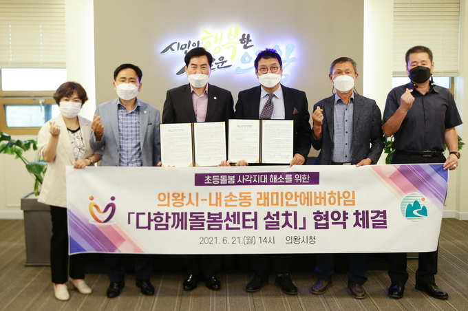 김상돈 의왕시장(사진 왼쪽 세번째)과 내손동 래미안에버하임 아파트 전도식 입주자대표가 21일 시청 시민소통실에서 '다함께돌봄센터 설치 협약'을 체결했다. 협약식 참가자들이 기념촬영을 하고 있다. (사진=의왕시 제공)