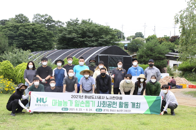 화성도시공사 임직원들이 송산면 지화리 마늘 농가를 찾아 일손돕기 봉사활동을 마치고 기념촬영을 하고 있다. (사진=화성도시공사 제공)
