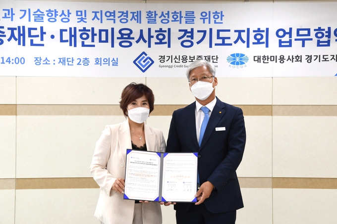 이민우 경기신용보증재단 이사장(오른쪽)이 29일 대한미용사회 경기도지회와 경기도 미용업 발전과 기술향상 및 지역경제 활성화를 위한 업무협약을 체결했다. (사진= 경기신보 제공)