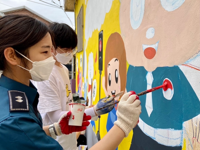 파주경찰서 직원과 학생들이 공동으로 벽화를 그리고 있다.(사진=파주경찰서 제공)