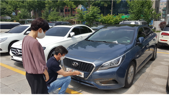 김포시 직원들이 자동차 등록 상습체납차량 번호판을 영치하기 위해 번호판을 떼고 있다.( 사진=김포시 제공)