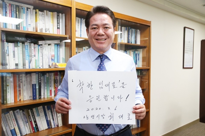 최대호 안양시장이 '착한 임대료를 응원한다'는 내용이 담긴 팻말을 들고 있다. (사진=안양시 제공)