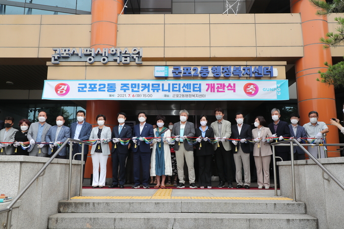 군포2동 주민커뮤니티센터 개관식에서 한대희 시장(왼쪽에서 8번째) 등 참석자들이 테이프 커팅을 하고 있다. (사진=군포시 제공)