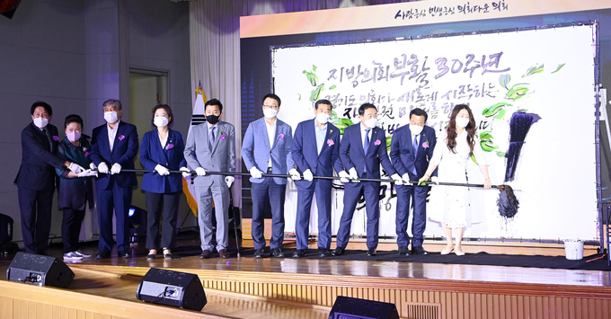 8일 경기도의회 대회의실에서 열린 '지방의회 부활 30주년 기념식'에 참석한 장현국 경기도의회 의장과 의장단, 역대 의장 등 내빈들이 기념 퍼포먼스를 하고 있다. (경기신문 = 조병석 기자)