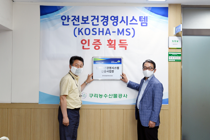 안승남 구리시장과 구리농수산물공사 김성수 사장이 지난 8일 안전보건경영시스템 KOSHA-MS 인증 현판식을 진행하고 있다. (사진=구리농수산물공사 제공)