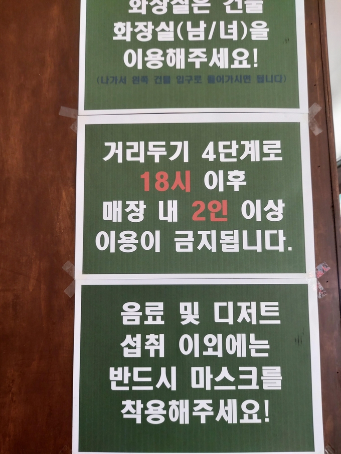 12일 수원시 팔달구에 위치한 한 카페에 수도권 거리두기 4단계로 인한 매장 내 2인 이상 금지 안내문이 붙어 있다. (사진=편지수 기자)