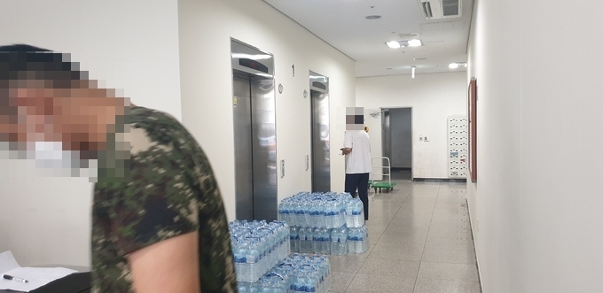 생활치료센터 전환을 위해 작업 중인 군인과 엘레베이터를 기다리는 경기대 학생 (사진 = 박환식 기자)